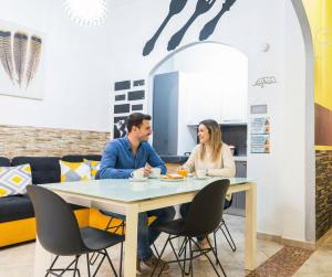 蒙塞拉托"La Casa di Ryan" - Intera casa - Policlinico - Cittadella - Tra Cagliari e il mare的坐在桌子上的男人和女人