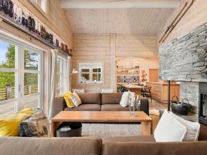 a living room with a couch and a fireplace at Family Cabin With Hot Tub In Hønedalen in Haugen