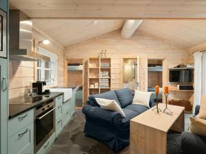 a living room with a blue couch in a tiny house at Family Cabin With Hot Tub In Hønedalen in Haugen