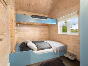 a small bedroom with a bed in a wooden wall at Family Cabin With Hot Tub In Hønedalen in Haugen