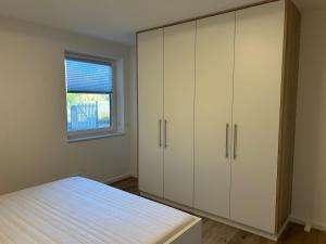 Schlafzimmer mit weißen Schränken und einem Bett in der Unterkunft Ferienwohnung in Erfurt