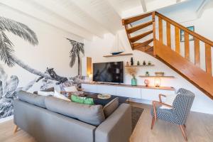 Una sala de estar con un sofá y una escalera. en Paradis côtier - Maison vue mer à Loguivy, en Loguivy-Plougras