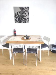 un tavolo con sedie e un dipinto di una zebra di Penthouse Apartment im 20 Stock a Augusta (Augsburg)