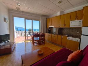 a living room with a table and a kitchen with a view at Apartamentos Bellavista in Puerto de Mazarrón