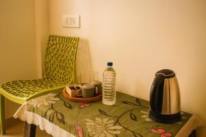 a table with a coffee maker on a table with a chair at Hotel Amore Mio Morjim - Beachfront Hotel on Morjim Beach in Morjim
