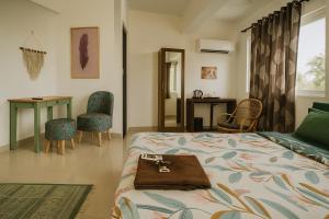 a bedroom with a bed and a desk and chairs at Hotel Amore Mio Morjim - Beachfront Hotel on Morjim Beach in Morjim