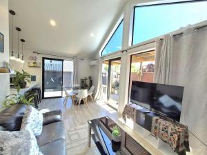 a living room with a large flat screen tv at Amie's Charming Villa in Tauranga