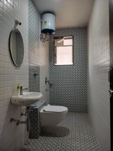 un bagno con un water, un lavandino e uno specchio di Vrindavan homestay Panaji 1BHK a Batim