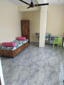 una camera da letto con due letti e un ventilatore a soffitto di Vrindavan homestay Panaji 1BHK a Batim Altre 8 foto