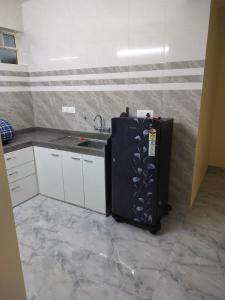 una cucina con frigorifero nero e lavandino di Vrindavan homestay Panaji 1BHK a Batim