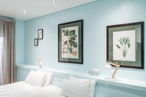 a bedroom with blue walls and a bed with white pillows at The Village Suites in Windhoek