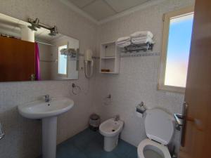 a bathroom with a sink and a toilet and a mirror at Apartamentos Bellavista in Puerto de Mazarrón +46 photos