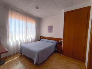 a bedroom with a bed and a large window at Apartamentos Bellavista in Puerto de Mazarrón