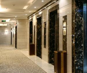 un hall avec une rangée d'ascenseurs dans un bâtiment dans l'établissement رتاج إن, à Al Khansāk