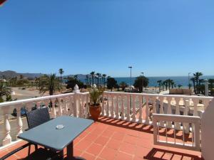 a blue table and chairs on a balcony with the ocean at Apartamentos Bellavista in Puerto de Mazarrón