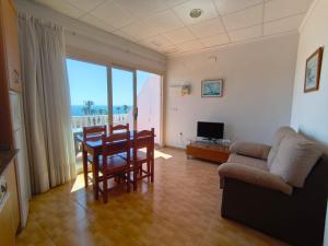 a living room with a couch and a table and chairs at Apartamentos Bellavista in Puerto de Mazarrón