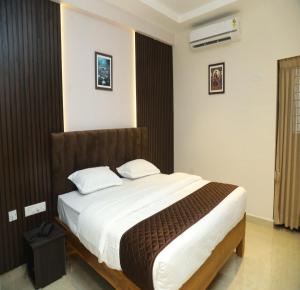 ein Schlafzimmer mit einem großen Bett mit weißer Bettwäsche in der Unterkunft SK Home Stay in Mayiladuthurai + 21 Fotos