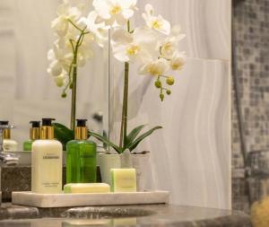 un comptoir de salle de bain avec un vase de fleurs blanches dans l'établissement رتاج إن, à Al Khansāk