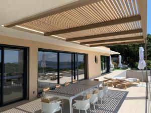 un patio con tavolo e sedie sul tetto di Villa Arizona a Port Grimaud