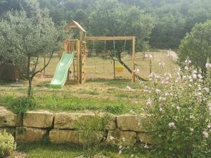 梅内尔伯La Carriole dans le jardin的一个带绿色滑梯的游乐场