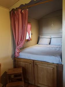 梅内尔伯La Carriole dans le jardin的一间有窗户的小房间里的一张床