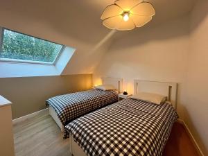 two beds in a attic room with a window at L'Escale Champenoise - independent accommodation in Hautvillers