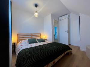 a bedroom with a large bed with a black blanket at L'Escale Champenoise - independent accommodation in Hautvillers +3 photos