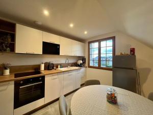 a kitchen with white cabinets and a table and a window at L'Escale Champenoise - independent accommodation in Hautvillers
