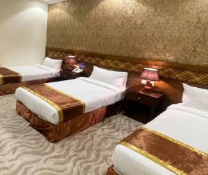une chambre d'hôtel avec deux lits et deux lampes dans l'établissement رتاج إن, à Al Khansāk