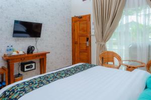 a bedroom with a bed and a tv and a window at Bintan Exotica Resort By WH - Free Breakfast in Berakit