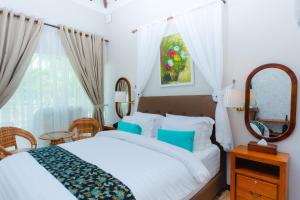 a bedroom with a white bed and a mirror at Bintan Exotica Resort By WH - Free Breakfast in Berakit