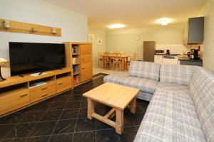 a living room with two couches and a flat screen tv at Ferienwohnung Quartier18-09 strandnah in Karlshagen