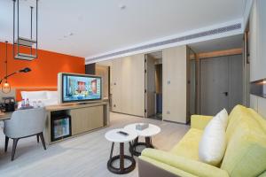 a living room with a couch and a tv at Wyndham Handan Congtai in Handan