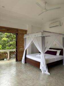 un dormitorio con una cama con dosel en CoCoSuRf House, Luxury among palms, en Hikkaduwa