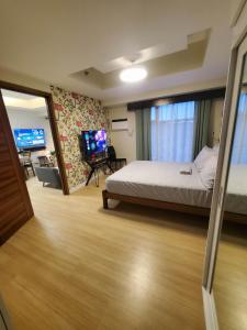 une chambre d'hôtel avec un lit et une télévision dans l'établissement 1bedroom suite 50th floor with balcony and bathtub at Horizons 101 tower 1, à Cebu