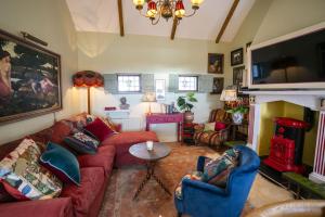 een woonkamer met een rode bank en een open haard bij Halyon Village in Greencastle