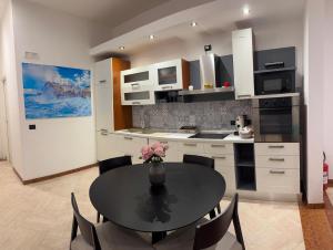 a kitchen with a table with a vase of flowers on it at Graziano's House Case Vacanze in Bari