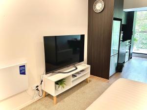 a living room with a flat screen tv on a cabinet at Modern apartment in the city center in Auckland