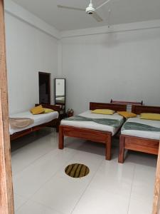 ティッサマハーラーマにあるWild Safariのベッド3台と鏡付きの部屋