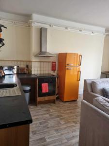 a kitchen with a yellow refrigerator and a couch at St Hilary Central Apartment in Llandudno