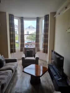 a living room with a couch and a coffee table at St Hilary Central Apartment in Llandudno