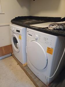 a washer and dryer sitting under a counter at St Hilary Central Apartment in Llandudno
