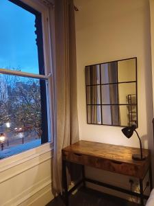 a lamp on a table in front of a window at St Hilary Central Apartment in Llandudno