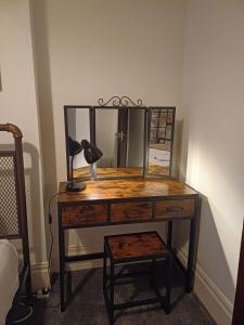 a dressing table with a mirror and a lamp on it at St Hilary Central Apartment in Llandudno +2 photos