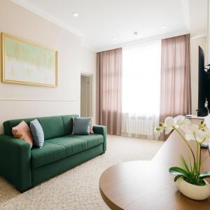 uma sala de estar com um sofá verde e uma mesa em Maestro Address Baku Hotel em Baku