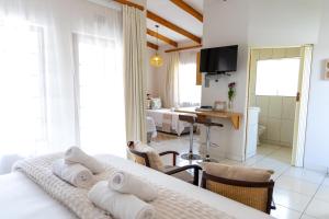 um quarto com uma cama e uma sala de estar em LA Guesthouse em Piet Retief