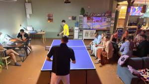 - un groupe de personnes dans une salle avec des tables de ping-pong dans l'établissement Beach Jungle, à Ko Chang