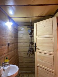a bathroom with a shower and a sink and a door at Amazigh van Agafay in Oumnas