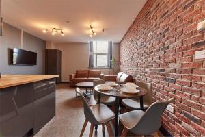 a room with a brick wall and a table and chairs at Apartment Stays in Newcastle upon Tyne