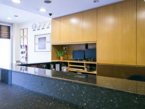 a lobby with a large counter with wooden cabinets at Hotel 81 Balestier in Singapore